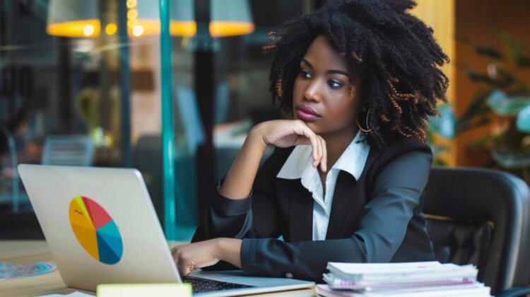 In this image, we see a young professional woman immersed in her work, seated confidently at her desk in a stylish office environment. Her focused gaze and the poised hand on her chin suggest deep concentration and determination. The laptop in front of her and piles of documents to her side indicate a busy workflow. Illuminated by the warm ambient lighting and surrounded by the vibrancy of a contemporary workspace, the scene captures the essence of modern professionalism.