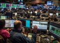 A dynamic scene unfolds on the trading floor of a stock exchange where traders and financial analysts are deeply engrossed in their work. Surrounded by an array of computer monitors displaying real-time market data, these professionals are the lifeblood of the financial marketplace, making split-second decisions that could influence global economies. Amidst the buzz of activity, the focus is palpable as each individual works to ensure the best outcomes for their clients and themselves in this high-stakes environment.